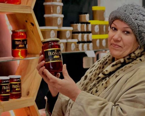Madame Naïma Chabaan, experte en apiculture, présentant un pot de miel artisanal dans sa boutique de produits du terroir